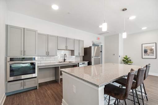 A kitchen with a granite countertop and stainless steel appliances.