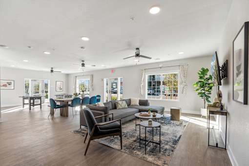 A spacious living room with a variety of furniture and a ceiling fan.