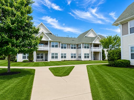 A large white house with a tree in front of it.