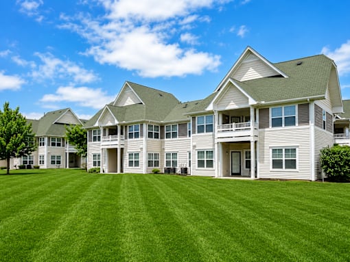 A large, well-maintained house with a green lawn in front.