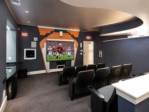 A room with a large screen and chairs.