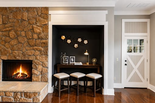 A cozy room with a stone fireplace and a wooden table.