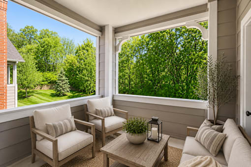 A sunny day in a cozy balcony with a table and two chairs.