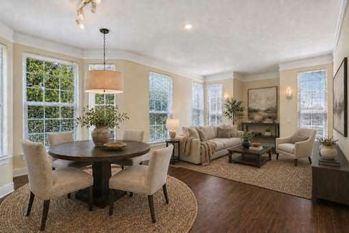 A well-lit living room with a round table and chairs.