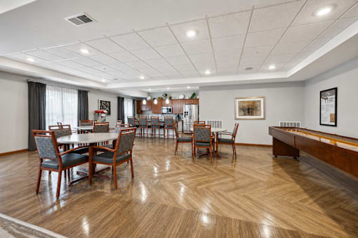 A room with a pool table and a dining table with chairs.
