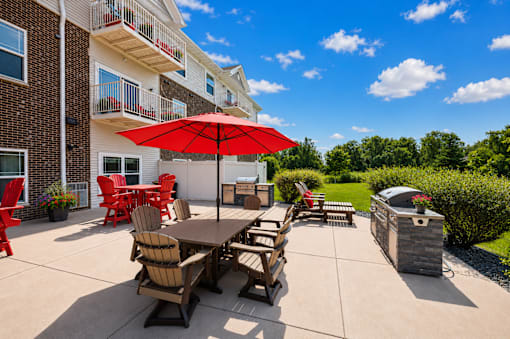 A patio with a table and chairs and an umbrella.