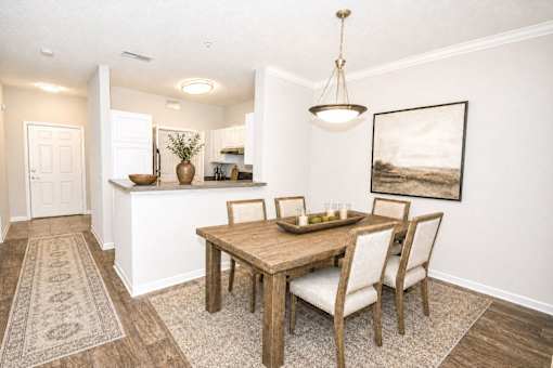 A dining room with a wooden table and chairs.
