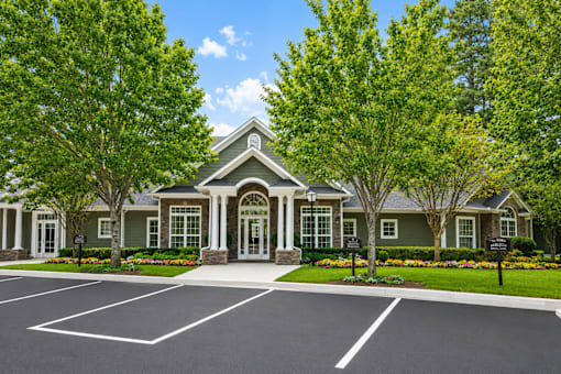 A large house with a green lawn and trees in front.
