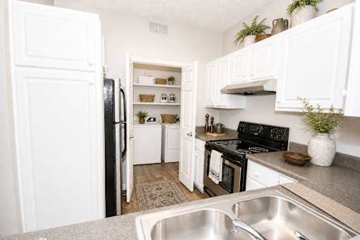 A kitchen with white cabinets and a black stove top oven.