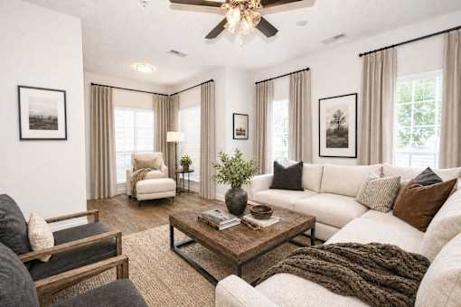 A living room with a white couch, a wooden coffee table, and a ceiling fan.