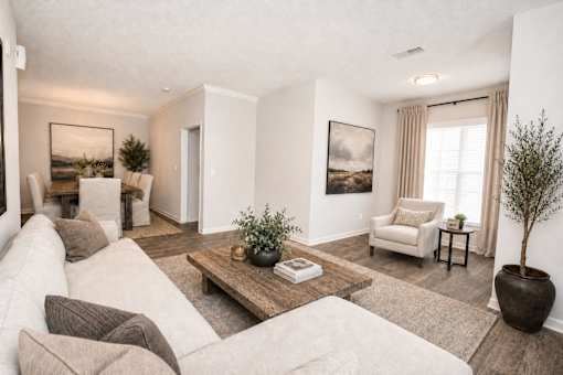 A living room with a white couch, a coffee table, and a painting on the wall.