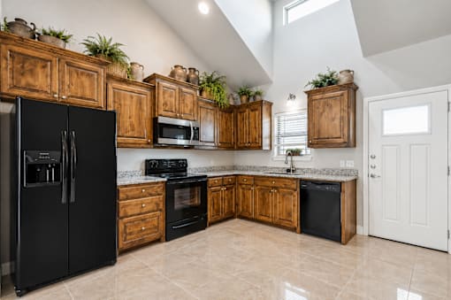 A kitchen with black appliances and wooden cabinets.