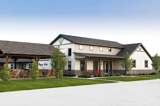 A white house with a black roof and a sign that says "Welcome".