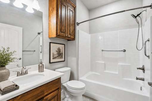 A white bathroom with a white toilet, a white sink, and a white bathtub.