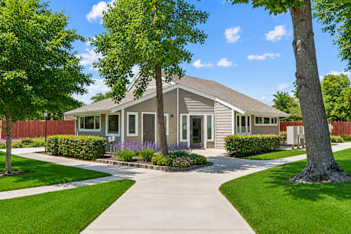 A house with a grey roof and a white fence.