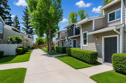 A row of houses with a sidewalk in between.