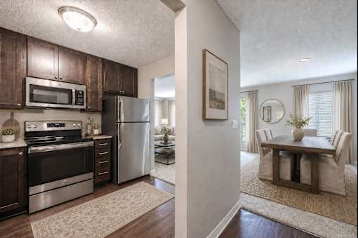 A kitchen with dark wood cabinets and stainless steel appliances.