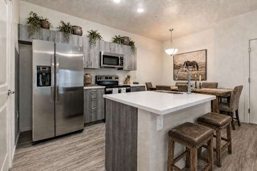 Modern kitchen with white countertops and island seating at Silver Ridge Apartments, Meridian, Idaho
