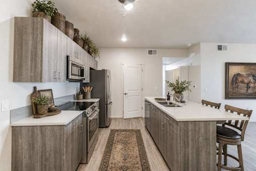 Modern kitchen with wood grain cabinetry and island at Silver Ridge Apartments, Meridian