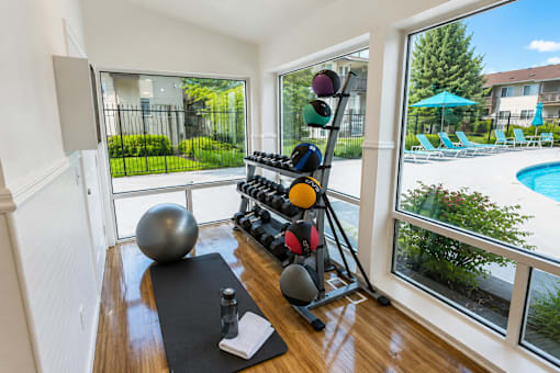 A room with a fitness equipment set up on the floor.