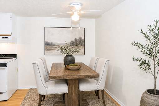 Dining area with wooden table and upholstered chairs at Stonetree Apartments, East Point