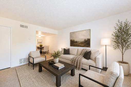 Living room with beige sofa and dark wood coffee table at Stonetree Apartments, East Point, 30344