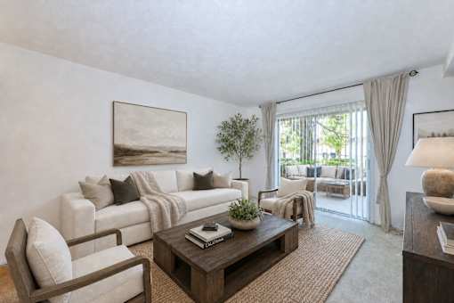 Living room with white sofa and patio access at Stonetree Apartments, East Point