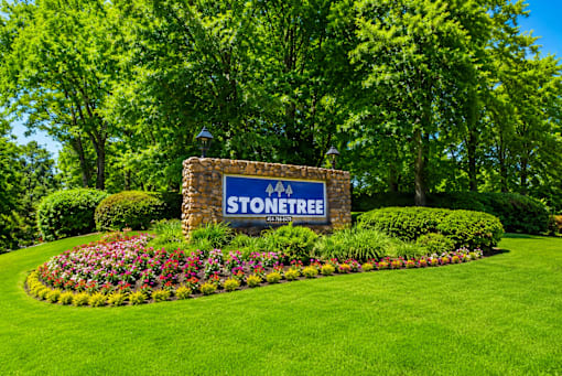Community entrance monument with colorful flower beds at Stonetree Apartments, Georgia, 30344