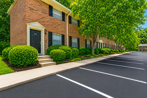 Brick townhome buildings with landscaped parking area at Stonetree Apartments, East Point, Georgia