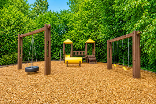 Playground area with swings and climbing structure at Stonetree Apartments, East Point, GA 30344