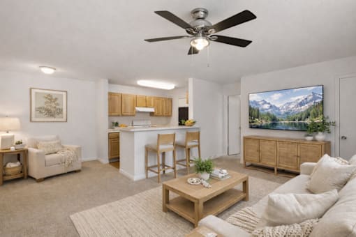 A living room with a ceiling fan and a painting of a mountain landscape on the wall.