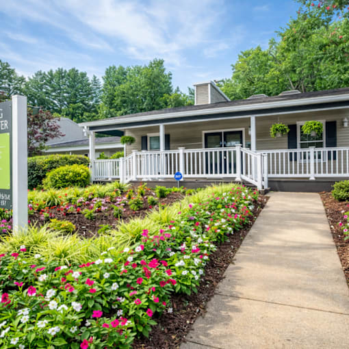 A house with a white fence and a sign that says "Welcome to Riverwood Estates".