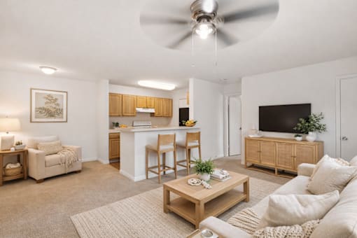 A living room with a white couch, a coffee table, and a ceiling fan.