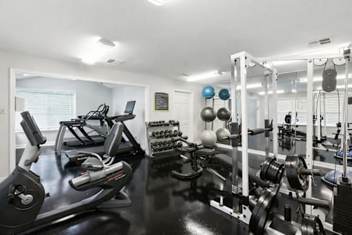 A well-equipped gym with various exercise machines and weights.
