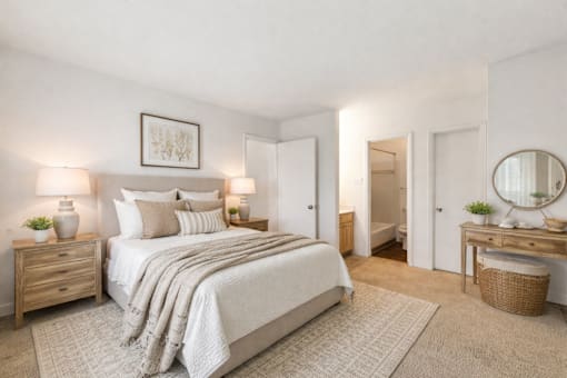 A bedroom with a large bed, a dresser, and a mirror.