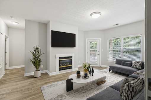 A modern living room with a fireplace and a flat screen TV mounted on the wall.