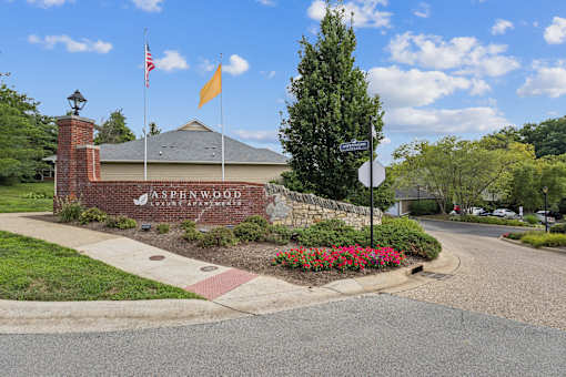 The Aspenwood Luxury Estate sign is displayed on a brick building.
