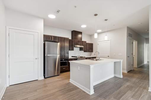 A modern kitchen with a white island and stainless steel appliances.