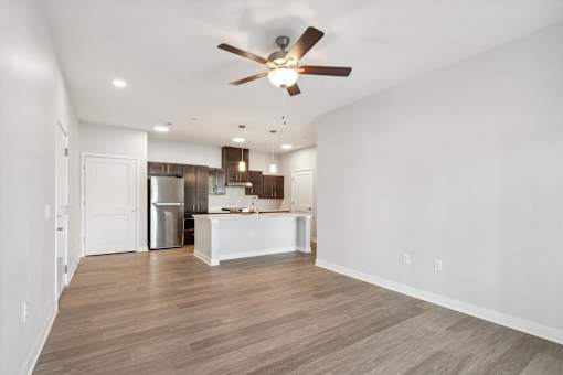 A spacious kitchen with a white island and wooden flooring.