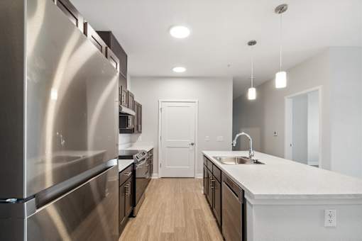 A modern kitchen with stainless steel appliances and wooden floors.