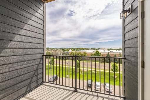 a balcony with a view of a yard and a balcony fence