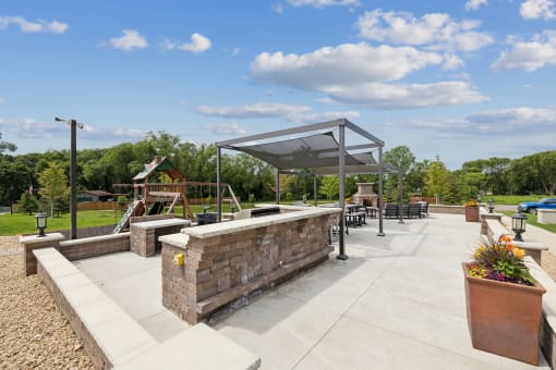 a patio with a seating area and a playground in a park