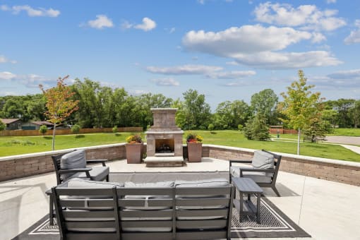 a patio with chairs and a fire pit