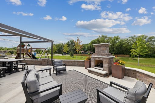 a large patio with furniture and a stone fireplace