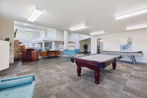 a games room with a pool table in the middle