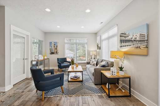 A living room with a blue chair and a grey couch.