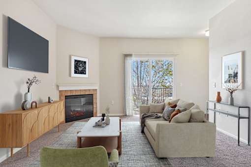 A living room with a fireplace, a couch, a chair, and a TV mounted on the wall.