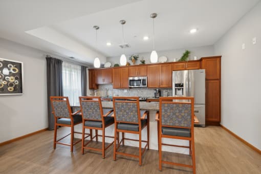 a kitchen with wooden cabinets and a long island with chairs