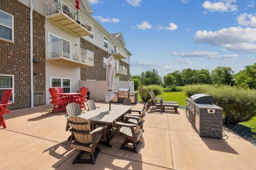 an outdoor patio with a table and chairs and a grill