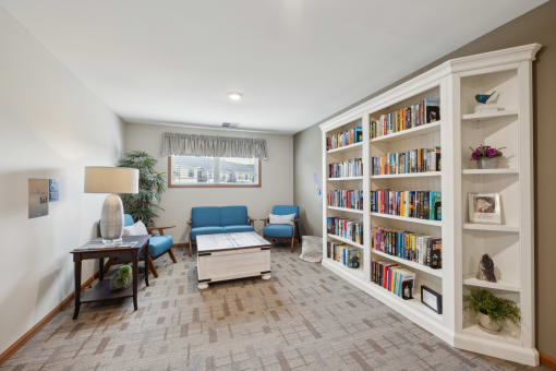 a living room with bookshelves and a couch and a table